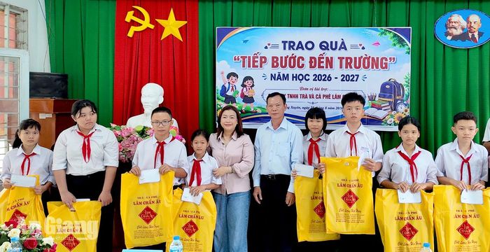 Chị Nguyễn Huỳnh Ngọc Chi (thứ năm, từ trái qua), Phó Giám đốc Công ty Trách nhiệm hữu hạn Trà cà phê Lâm Chấn Âu, phường Long Xuyên trao quà cho học sinh có hoàn cảnh khó khăn phường Long Xuyên. Ảnh: KIỀU DIỄM