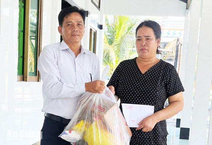 Ủy ban MTTQ Việt Nam xã Tân Thạnh trao nhu yếu phẩm cho bà Nguyễn Thị Phượng.