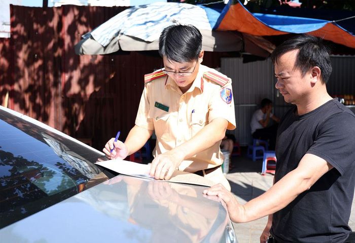  Cán bộ Phòng Cảnh sát giao thông (Công an thành phố) kiểm tra, hoàn thiện hồ sơ thủ tục hành chính. 