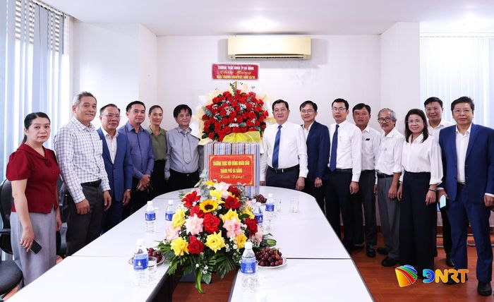 Phó Chủ tịch Thường trực HĐND thành phố Trần Phước Sơn (thứ 8 từ phải qua) tặng hoa chúc mừng Công ty TNHH Thương mại và Dịch vụ Tổng hợp Hòa Khánh. Ảnh: NGỌC HÀ