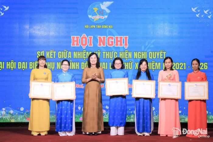 Bà Vũ Thị Hương (thứ 3 từ phải sang), Ủy viên Ban Thường vụ Hội LHPN thành phố, Phó Trưởng ban Công tác Phụ nữ thành phố nhận bằng khen của Trung ương Hội LHPN Việt Nam tại hội nghị sơ kết giữa nhiệm kỳ. Ảnh: Nga Sơn
