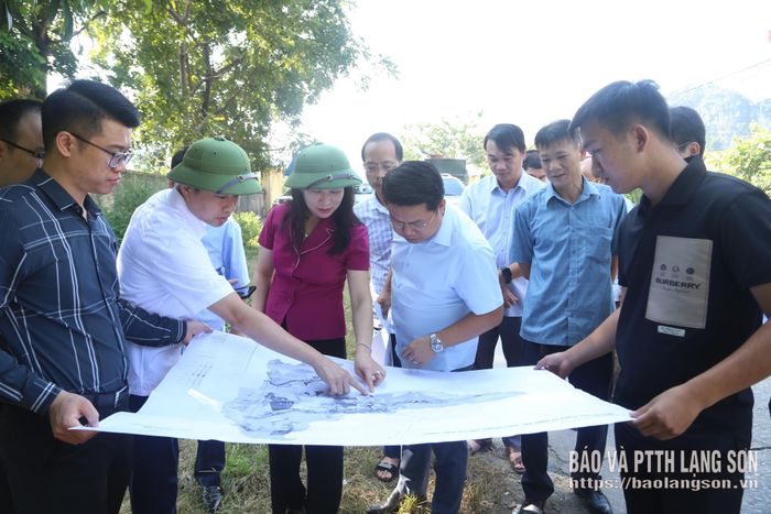 Đồng chí Trần Thanh Nhàn, Phó Chủ tịch UBND tỉnh và đoàn công tác xem xét bản vẽ quy hoạch khu vực dự kiến xây dựng Trường THPT Cai Kinh
