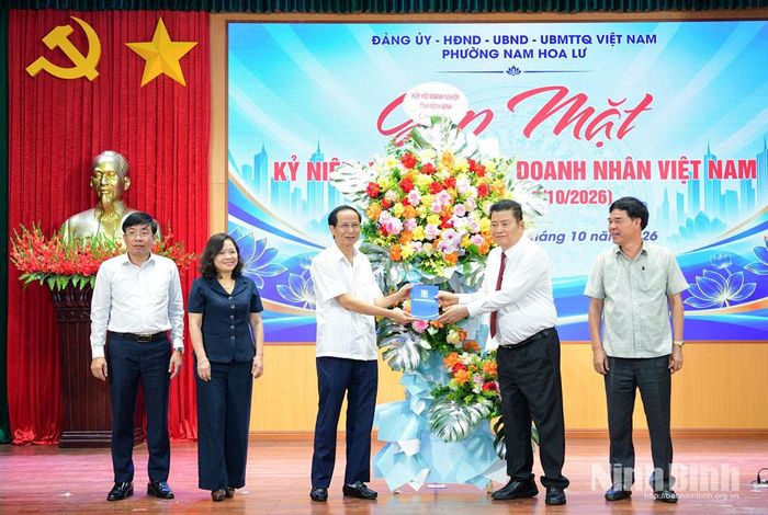 Ông Nguyễn Xuân Thành, Chủ tịch Hiệp hội Doanh nghiệp tỉnh, Chủ tịch Hội đồng quản trị Tập đoàn kinh tế Xuân Thành tặng hoa chúc mừng những kết quả đạt được của phường Nam Hoa Lư trong 9 tháng năm 2026.