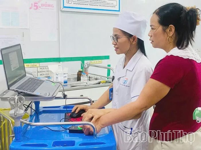 Trung tâm Y tế khu vực Tam Dương hướng dẫn người dân quét mã vân tay trong việc cấp thuốc.