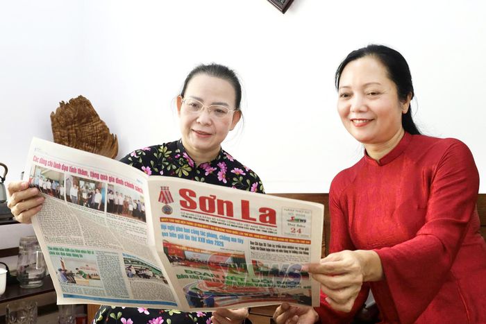 Sắc màu trang phục áo dài tô điểm không gian làm việc.