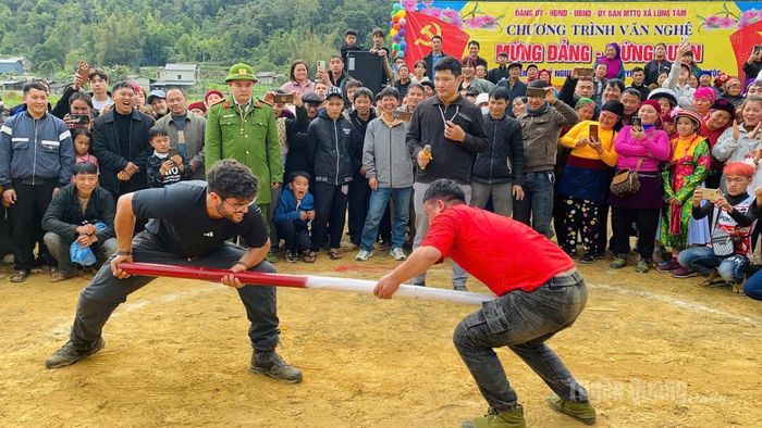 Du khách nước ngoài trải nghiệm môn đẩy gậy trong lễ hội xã Lùng Tám.