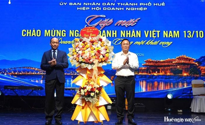 Đồng chí Lê Trí Thanh, Phó Bí thư Thành ủy, Chủ tịch UBND thành phố (bên phải) tặng hoa chúc mừng Hiệp hội Doanh nghiệp thành phố nhân.