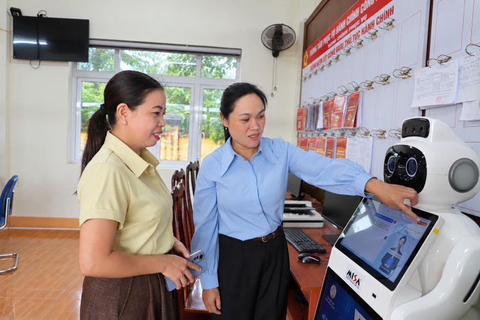 Bà Trần Thị Vân, Phó chủ tịch UBND xã Ea Knuếc kiểm tra hoạt động của robot AI đặt tại Trung tâm hành chính công của xã (Ảnh: Ngọc Hùng).