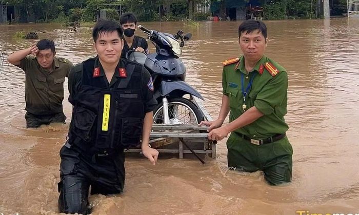 Công an "cứu hộ" xe máy cho người dân trên tuyến đường bị ngập nặng.
