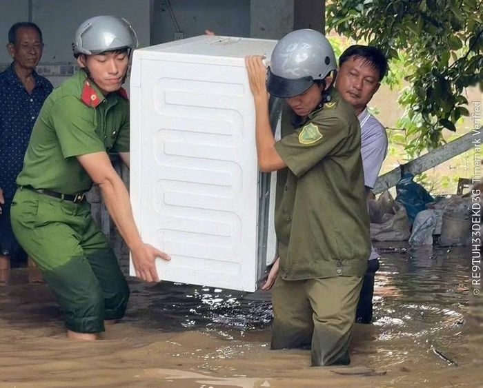 Công an cơ sở ở Đồng Nai hỗ trợ người dân di dời tài sản khi nhà cửa bị ngập nặng.