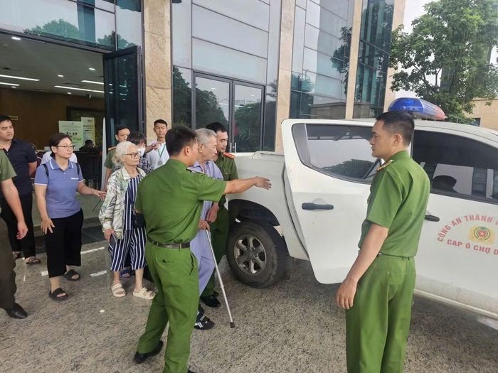 Lực lượng Công an giúp đưa đón người già yếu đến điểm nhận tiền bồi thường.