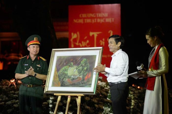  Họa sĩ Lê Sa Long tặng bức tranh ký họa các chiến sĩ đang tìm kiếm, quy tập hài cốt liệt sĩ tại Công viên Lê Thị Riêng cho đại diện lãnh đạo Bộ Tư lệnh TP Hồ Chí Minh. 