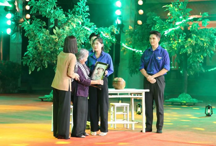  Hình ảnh người mẹ già bật khóc khi đón nhận tấm di ảnh con trai liệt sĩ của mình được phục dựng. 