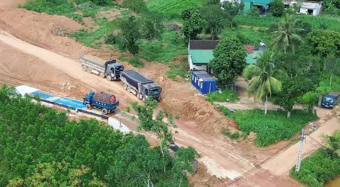 Đoàn xe lách trạm cân để đi ra ngoài đổ đất cho dự án san lấp tuyến cao tốc Vinh. -Thanh Thủy. Ảnh: HQ