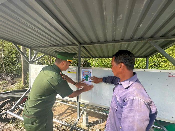 Cán bộ, chiến sĩ Đồn Biên phòng Đất Mũi dán mã QR tại các điểm sinh hoạt văn hoá của ấp, tạo điều kiện để người dân sử truy cập thông tin bằng điện thoại thông minh.