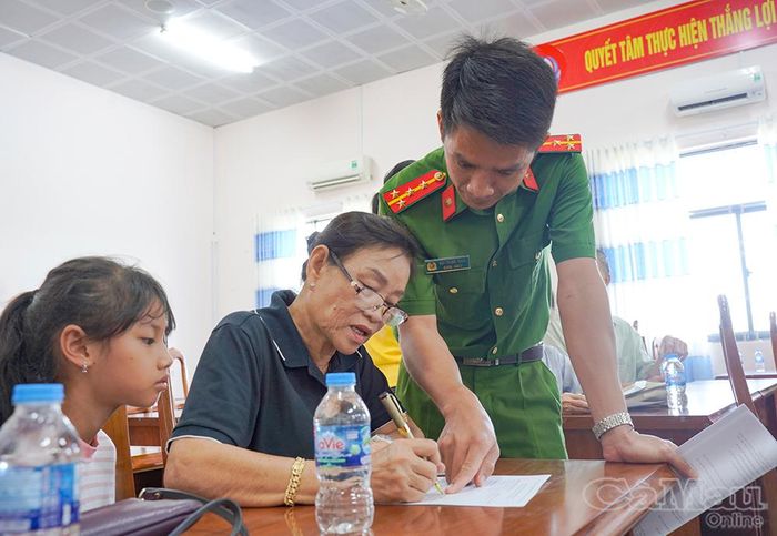Cán bộ công an hướng dẫn thân nhân liệt sĩ kê khai thông tin trước khi thu nhận mẫu ADN.