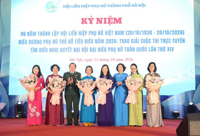 Thiếu tướng Lê Như Đức, Phó Chủ tịch Ủy ban MTTQ Việt Nam thành phố, Chủ tịch Hội Cựu chiến binh thành phố Hà Nội tặng hoa các nữ lãnh đạo nữ. Ảnh: Nguyệt Ánh