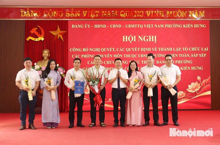 Đồng chí Trần Mạnh Hải, Phó Chủ tịch UBND phường tặng hoa chúc mừng phòng mới sau sắp xếp. Ảnh: Tuấn Điệp