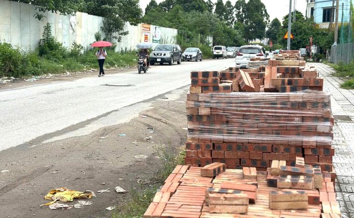 Vật liệu xây dựng tập kết thiếu gọn gàng, lấn ra vỉa hè khu vực sân bóng An Thọ, ảnh hưởng đến không gian dành cho người đi bộ. Ảnh: NT