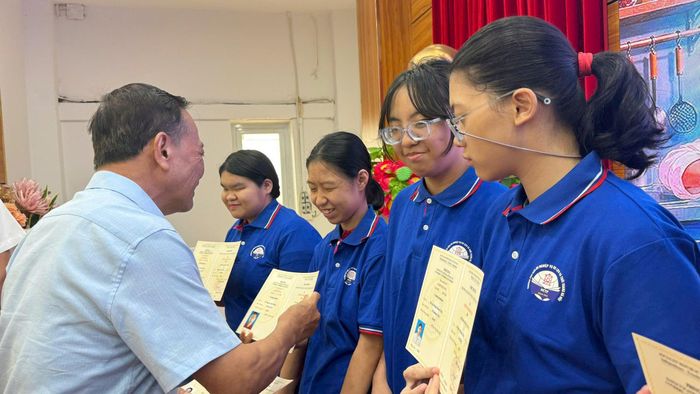Chủ tịch Hội Cứu trợ trẻ em khuyết tật Hà Nội Nguyễn Kim Hoàng trao chứng chỉ sơ cấp nghề cho các em học sinh Trường PTCS Nguyễn Đình Chiểu. Ảnh: Mai Hoa