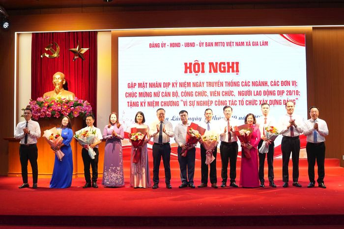 Lãnh đạo xã Gia Lâm tặng hoa chúc mừng các cơ quan, tổ chức có ngày truyền thống trong tháng 10. Ảnh: Hoàng Anh