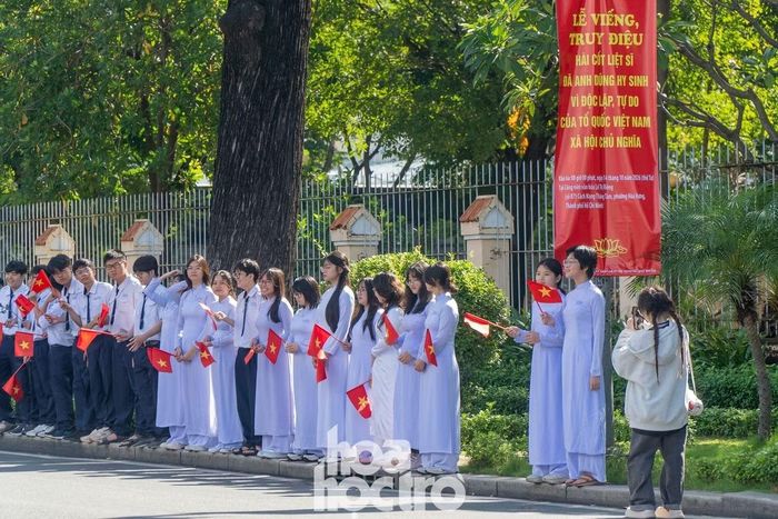 Học sinh các trường THPT nằm trên trục đường Điện Biên Phủ (phường Xuân Hòa) đứng chờ đoàn xe chở 731 hài cốt các anh hùng liệt sĩ đi qua.