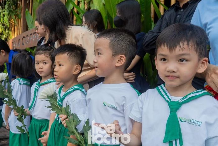 Hàng dài học sinh cùng người dân đứng kín hai bên trục đường Điện Biên Phủ đón đoàn xe chở hài cốt liệt sĩ đi qua.