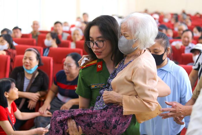 Hình ảnh nữ Cảnh sát khu vực Công an phường Hà Đông bế cụ bà - thân nhân liệt sĩ tuổi cao sức yếu di chuyển trong hội trường lấy mẫu ADN khiến bao người chứng kiến không khỏi nghẹn ngào