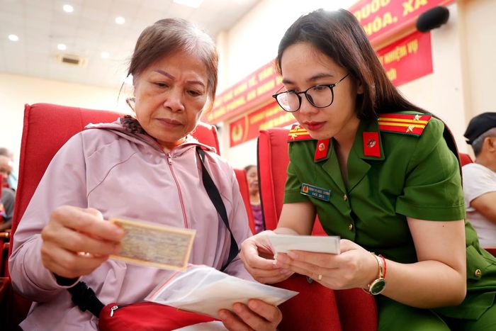 Trung tá Trịnh Thị Ngọc Quỳnh - Cảnh sát khu vực CAP Hà Đông chăm chú xem xét tỉ mỉ từng tấm ảnh, kỷ vật do thân nhân liệt sĩ cung cấp