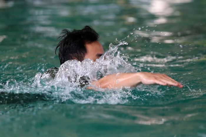 Các chiến sĩ thực hiện bài kiểm tra thể lực bơi cứu đuối trong điều kiện mô phỏng khắt khe
