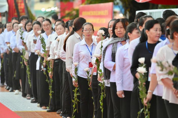 Đông đảo đại biểu, người dân cầm hoa cúc trắng, xếp hàng vào dâng hương trong khu vực diễn ra nghi thức cầu nguyện. Ảnh: Hoài Bảo.