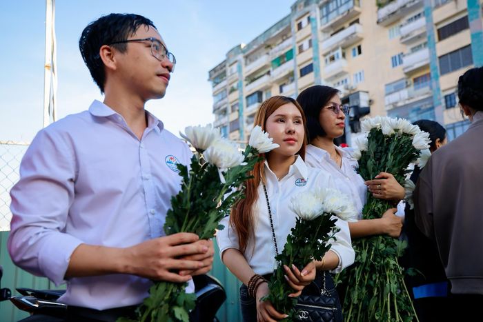 Anh Trương Thành Trí (TP Thủ Đức cũ) cùng khoảng 70 thành viên trong nhóm có mặt từ sáng sớm để trao hoa cúc trắng cho người dân đến tiễn đưa các liệt sĩ. Từ tối hôm trước, nhóm đã hỗ trợ trang trí bên trong khu vực tổ chức lễ, đồng thời chuẩn bị hơn 700 bông cúc trắng để phát miễn phí. Số hoa này do một người hỗ trợ gửi tặng nhóm. Ảnh: Phương Lâm.