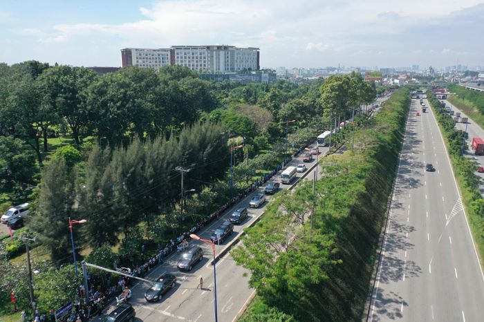  Đoàn xe di chuyển trên Xa lộ Hà Nội. Bên đường, người dân đứng tiễn đưa các liệt sĩ. Ảnh: Quỳnh Danh. 