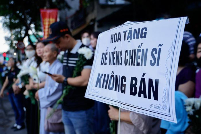 Nhiều người lớn tuổi hòa vào dòng người xếp hàng hai bên đường, tiễn đưa các liệt sĩ. Ảnh: Phương Lâm.