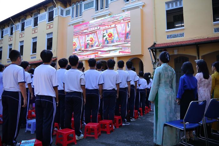  Khoảng 8h, trước giờ tập trung, học sinh lớp 11P1, trường THPT Nguyễn Thị Minh Khai (TP.HCM), chuẩn bị những bông hoa cúc trắng và cờ Tổ quốc. Các em sẽ cùng thầy cô tập trung tại tuyến đường Điện Biên Phủ để tiễn đưa 731 liệt sĩ được quy tập tại Công viên Lê Thị Riêng về nơi an nghỉ tại Nghĩa trang Liệt sĩ TP.HCM. Ảnh: Võ Kỳ. 