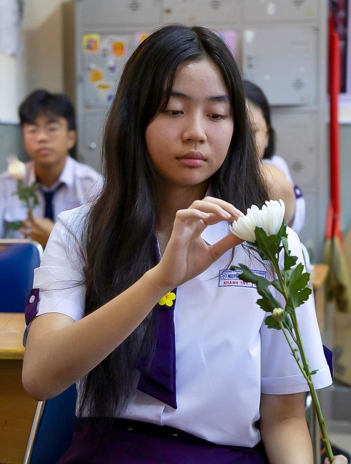  Với Khánh Thy, học sinh lớp 11P1, đây là lần đầu tiên em được trực tiếp tham gia hoạt động tiễn đưa các liệt sĩ. Tự tay chuẩn bị từng bông hoa, nữ sinh không giấu được sự xúc động. Là học sinh của ngôi trường mang tên nhà cách mạng Nguyễn Thị Minh Khai, Thy càng cảm nhận rõ hơn ý nghĩa của buổi lễ. Em bày tỏ lòng biết ơn những người đã hy sinh thân mình để giành lại độc lập, tự do cho dân tộc.