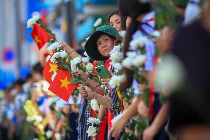 Người dân hướng về đoàn xe đưa các liệt sĩ về nơi an nghỉ. Ảnh: Nghĩa Phạm.
