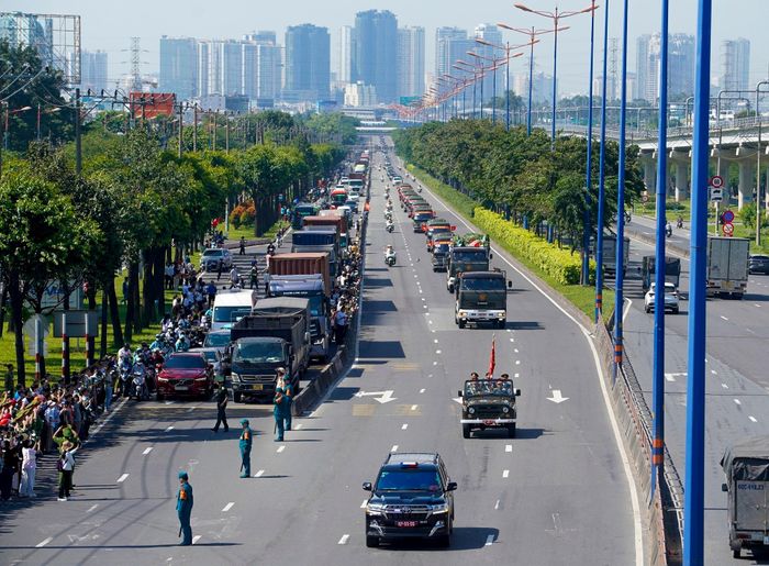 Dòng người nghẹn ngào, vẫy tay tiễn biệt khi đoàn xe chở hài cốt các liệt sĩ đi qua. Ảnh: Trung Hiếu.