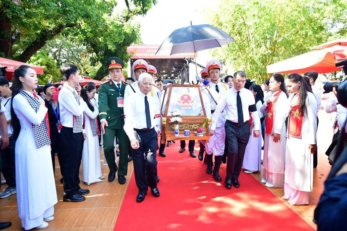 Thủ tướng Chính phủ Lê Minh Hưng và nguyên Chủ tịch nước Nguyễn Minh Triết di chuyển giá khiêng hài cốt liệt sĩ lên xe để đến Nghĩa trang liệt sĩ TP.HCM. Ảnh: BTC