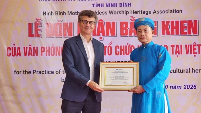 Ông Jonathan Wallace Baker, Trưởng Đại diện UNESCO tại Việt Nam trao bằng khen cho Nghệ nhân nhân dân Phạm Hải Hậu