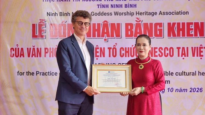 Ông Jonathan Wallace Baker, Trưởng Đại diện UNESCO tại Việt Nam trao bằng khen cho Nghệ nhân ưu tú Trần Thị Huệ