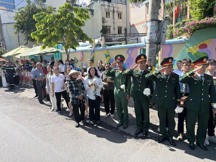 Đông đảo các tầng lớp nhân dân đứng dọc hai bên đường tiễn đưa, tưởng nhớ các Anh hùng liệt sĩ được quy tập tại Công viên Lê Thị Riêng về nơi an táng. Ảnh: Trung Tuyến - TTXVN
