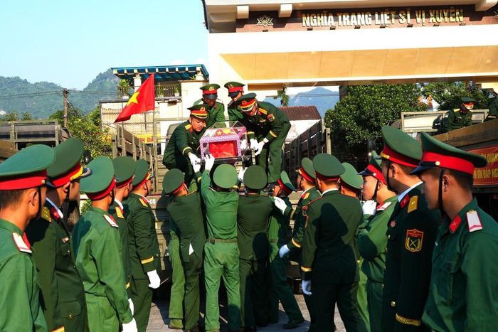 Cán bộ, chiến sĩ Bộ Chỉ huy Quân sự tỉnh Tuyên Quang đón linh cữu hài cốt các liệt sĩ xuống xe tại Nghĩa trang Liệt sĩ Vị Xuyên