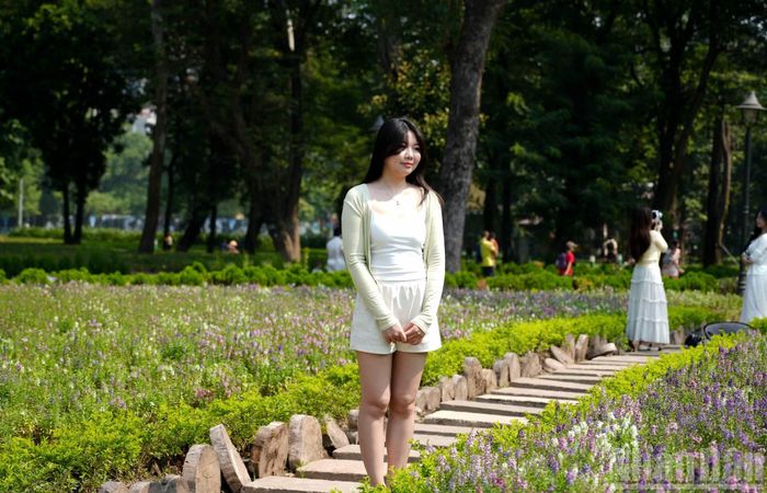 Dù thời tiết ban ngày có lúc oi bức, nắng nóng, nhiệt độ chạm ngưỡng 34 độ C, nhiều người vẫn kiên nhẫn xếp hàng chờ đến lượt chụp ảnh.
