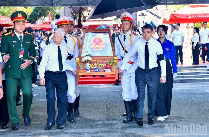 Nguyên Chủ tịch nước Nguyễn Minh Triết và Thủ tướng Chính phủ Lê Minh Hưng cùng thực hiện nghi thức đưa hài cốt các Anh hùng liệt sĩ từ Công viên Lê Thị Riêng về Nghĩa trang Liệt sĩ Thành phố Hồ Chí Minh. (Ảnh: THANH GIANG)