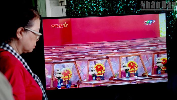 Người dân mặc niệm tưởng nhớ các liệt sĩ khi theo dõi chương trình truyền hình trực tiếp.
