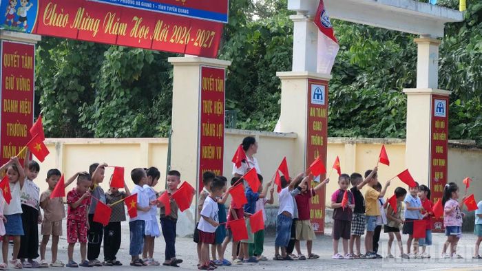 Học sinh Trường Mầm non Hoa Sen, phường Hà Giang 1 cầm cờ, tiễn các Anh hùng liệt sĩ về Nghĩa trang liệt sĩ Vị Xuyên. (Ảnh: KHÁNH TOÀN)