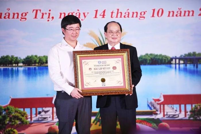 Chủ tịch Ủy ban nhân dân tỉnh Quảng Trị Bùi Hoàng Phương đón nhận bằng tôn vinh giá trị nội dung Kỷ lục Việt Nam cho Di tích lịch sử quốc gia Bến phà II Long Đại. (Ảnh: HG)