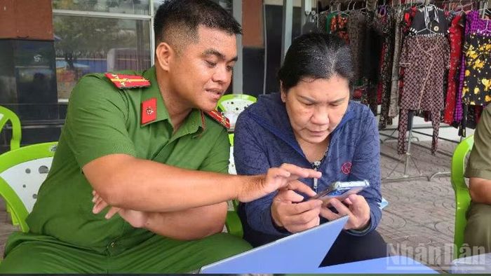 Cán bộ, chiến sĩ Công an phường Vị Thanh hướng dẫn hóa hồ sơ cho người dân. (Ảnh: VĂN ÚT)
