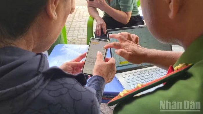 Cán bộ, chiến sĩ Công an phường Vị Thanh tận tình hướng dẫn, hỗ trợ tích hợp thông tin và giải đáp những nội dung chưa rõ. (Ảnh: VĂN ÚT)
